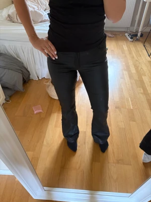 Svarta bootcut byxor i skinnimitation - Säljer ett par svarta byxor i skinnimitation med bootcut passform. Byxorna är midwaist. Använda den 1 gång. Från ONLY storlek M30. Skriv för frågor eller prisförslag