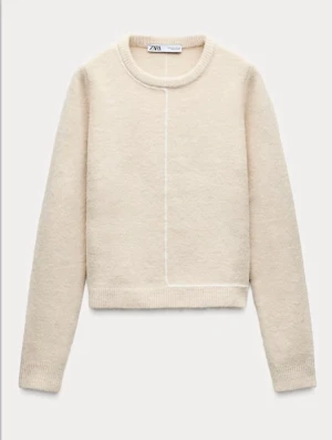 Beige stickad tröja från Zara - Säljer denna eftertraktade beigea stickade tröjan från Zara med en vit söm framtill, som inte säljs längre! Storlek XL men då modellen är tänkt att sitta åt så passar den precis som man vill ha sina stickade på  mig som i vanliga fall har S på stickade! Kolla gärna in mina andra annonser