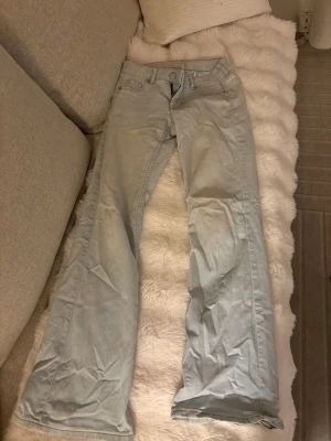 Ljusblå bootcut jeans - Säljer ett par supersnygga ljusblå jeans med bootcut passform och klassisk femficksdesign. Jeansen har låg midja och är tillverkade i mjukt denimtyg. Snyggt ljusblå ton som passar till många olika stilar. Storlek 34 men väldigt stretchiga så passar större storlekar också💕