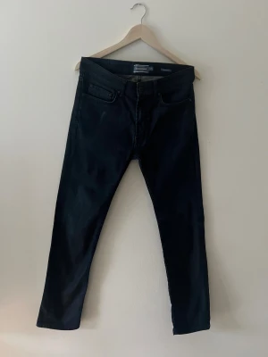 Ett par väldigt mörkblåa Dressman jeans - Ett par väldigt mörkblåa Dressman hans i ett mycket bra sick storlek står vid sidan av 3 bilden på Dressman märket