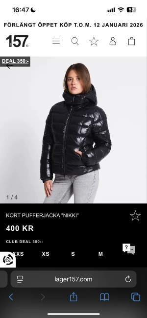 Svart kort pufferjacka Nikki Lager 157 - Svart, glansig och kort pufferjacka från Lager 157, modell Nikki. Jackan har en hög krage, huva och dragkedja framtill. Storlek Xs, använt max 2 gånger 