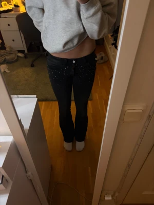 Lågmidjade jeans från H&M - Fint par lågmidje jeans från H&M med fina detaljer på fickorna i storlek xs/164 . Säljs inte längre därav det högre priset.