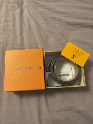 Svart rutigt bälte med silver spänne - Jag säljer ett svart rutigt bälte med silver spänne. Allt som finns på bilderna är inkluderar(Låda,kvitto och certifikat kort). Man får lov att höra av sig vid intresse