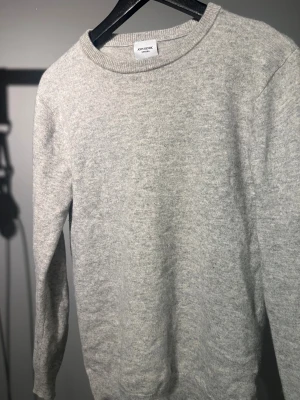 Grå stickad tröja från John Henric - En stilren grå stickad tröja från John Henric. Material Kashmir, storlek S, tvättad rätt och välanvänd. Pyttelitet hål i armvecket. Skickas direkt.