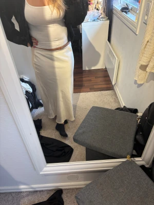 Vit långkjol från Zara i satin - Säljer en stilren crémevit långkjol från Zara i storlek M. Kjolen har en mjuk satinfinish som ger en snygg glans och faller fint längs kroppen. Den har en rak och enkel siluett utan mönster eller detaljer, Vid snabb affär kan priset diskuteras. Har du frågor, bara att skriva💞