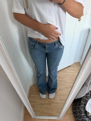 Lågmidjade jeans  - Jättesnygga i så najs färg, har en slitning nere på ena benet (se bild), jag är 168!
