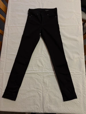 Svarta shaping skinny jeans B.Denim - Svarta shaping jeans från B.Denim i skinny fit med regular midja. Klassisk femficksmodell med dragkedja och knapp, tillverkade i stretchigt denimtyg för en tight och bekväm passform. Perfekta för dig som gillar en slimmad siluett.