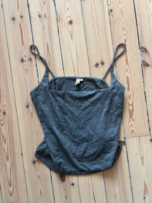 Croppat linne - Croppat linne i grått från Nelly. Grå och väldigt skönt tyg! Mindre i storleken skulle passa s-m bättre än L 