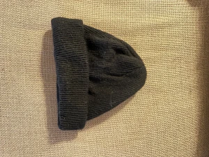 Svart ribbad mössa från Bik Bok - En stilren svart mössa från Bik Bok med ribbad struktur och uppvikt kant. 