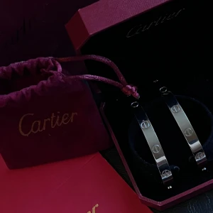 Cartie.r love armband - Cartie.r Love armband tillverkat i silver och stämplat med 18k guld, designat för unisex. Armbandet har en klassisk design med skruvdetaljer och levereras med originalförpackning och tillbehör.ordinarie pris:4,499kr