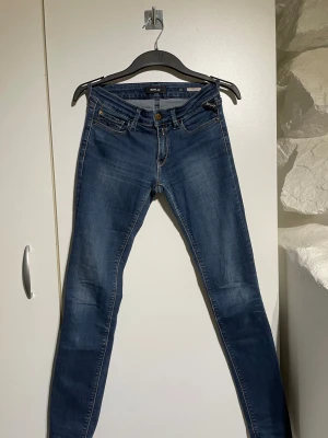 Replay Luz skinny jeans blå - Snygga blå Replay Luz jeans i skinny fit med klassisk femficksdesign och gul kontrastsöm. Jeansen har låg midja och är tillverkade i stretchigt denim för en tajt passform. Svart Replay-lapp bak i skinn och detaljerade bakfickor.