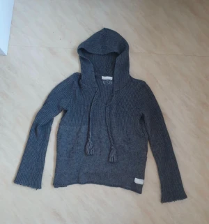 Grå stickad hoodie Odd Molly Str S - Säljer en snygg mörkgrå stickad hoodie från Odd Molly med långa ärmar och huva. Tröjan har ribbad struktur upptill och slätstickad nedtill, samt snörning med tofsar framtill. Super snygg säljer för att den är lite stor💕