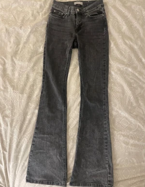 Mörkgråa perfect jeans från GinaTricot - (Perfect jeans) Bootcut jeans i svart tvätt från GinaTricot , storlek 32. Klassisk femficksmodell med dragkedja och knapp framtill. Jeansen har en snygg faded look och är tillverkade i stretchigt denim för skön passform. Tecken på användning längst ner på byxorna (syns på 5:te bilden)