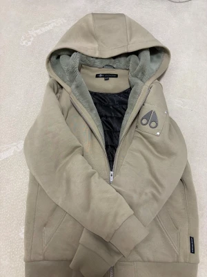 Beige hoodiejacka Moose Knucklers barn xxl - Beige hoodiejacka från Moose Knucklers i storlek XXL.  jackan är i barn storlek men passar från 165-175 pris varierar om du kan mötas i sthlm så får du den för 1800 genom plick 2000 pris kan discuteras via snabb affär 