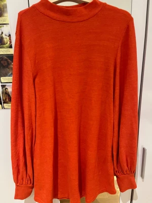 Orange tröja från Gina Tricot - Säljer en snygg orange tröja från Gina Tricot i storlek M. Tröjan har långa ärmar med lätt puff och breda muddar. Den är mjuk och skön, perfekt för lager-på-lager under hösten och vintern.