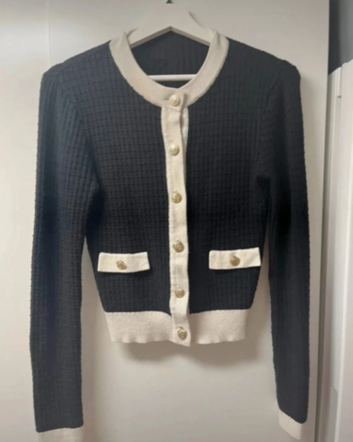 Svart och vit kofta med guldknappar