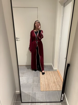 Open abaya  - Säljer min vinröda open abaya, den ser starkare röd ut än vad den är på bilden. Den är mer vinröd i verkligheten. Den har också fickor!!! ❤️ jag är 166 cm lång och har använt denna en gång tidigare i sommar. Finns inga defekter. Rosetterna är beiga 