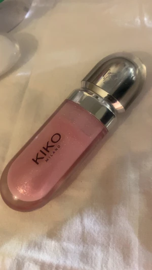 KIKO Milano 3D Hydra Lipgloss 05 - Säljer en KIKO Milano 3D Hydra Lipgloss i nyansen 05. Glanset har en skimrande ljusrosa färg och kommer i en snygg, rundad tub med silvrigt lock. Perfekt för dig som vill ha glansiga och fylliga läppar med extra lyster.