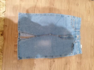 Jane midi jeanskjol från Cubus XS - Snygg ljusblå jeanskjol i midi-längd från Cubus, modell Jane Midi Skirt. Kjolen har klassiska jeansdetaljer som fickor, bälteshällor och knapp framtill. Materialet är en mix av bomull, viskos och polyester för skön passform. Den är i stl. Xs, sitter som s på mig som vanligtvis har xs. Den har en liten fläck från färg på framsidan, se bild 2. 