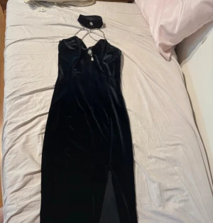 Svart sammetsklänning med pärldetalj - Elegant svart långklänning i sammet med smala kedjeband och en snygg slits framtill. I super bra skick!💕
