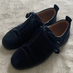 Blå sneakers från Christian Louboutin - Snygga blå sneakers i mocka från Christian Louboutin med den ikoniska röda sulan och diskret logotyp på hälen Levereras med originaltillbehör (kartong, påse, kvitton).