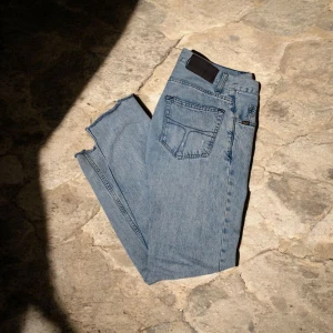 Tiger of Sweden ljusblå jeans  - Säljer ett par ljusblå jeans från Tiger of Sweden, modell Pistolero. De har klassisk femficksdesign, raka ben och snygga kontrastsömmar. Jeansen är tillverkade i bomull och har en stilren svart patch med logga bak i midjan.