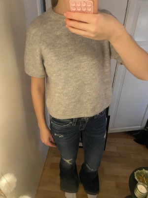 Grå stickad tröja Gina Tricot - En enkel och snygg grå stickad tröja från Gina Tricot. Modellen är kortärmad med rund hals och har en lös passform. Perfekt att slänga på sig när det är lite kyligt ute. Mjuk och skön kvalitet. Använt några gånger💗