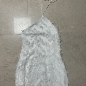 Vit klänning med fjädrar  - Vit klänning med fjädrar öppen rygg 