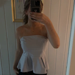 Ljusblå bandeau topp från H&M - Säljer en ljusblå bandeau topp från H&M i storlek M. Toppen är axelbandslös med volang nertill och har en figurnära passform. Perfekt för dig som vill ha en stilren och trendig look. Materialet känns mjukt och lätt mot huden. (Helt ny)