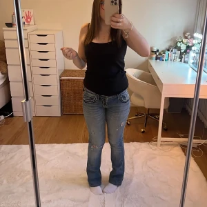 Miss Me blå bootcut jeans med broderi - Säljer ett par blå bootcut jeans från Miss Me med snygga kontrastsömmar och broderade bakfickor. Jeansen har låg midja, slitningar och detaljerade ficklock. Perfekt för dig som gillar en unik och cool denimstil. Priset kan absolut sänkas och diskuteras om du är redo att köpa de i stund. Skriv om fler frågor 💕💕De är inte mina bilder de är föra ägarens men är inte använda sen dess då dem aldrig kommer till användning