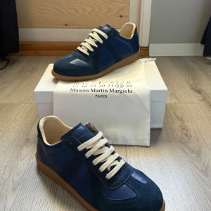Maison Margiela blå sneakers - PRIS KAN DISKUTERAS!  Säljer nu dessa feta Gats i storlek 44. Riktigt snygg mörkblå färg, passar perfekt nu till hösten 🤩 Bara blivit testade inomhus, så i princip oanvända.   Bara dustbag tillkommer, ingen box alltså ❗️  Ni vet varför de är billiga 🐼