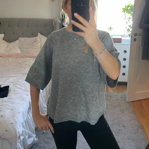 Grå stickad tröja med vida ärmar - Mysig grå stickad tröja med lite boxig passform och trekvartsärmar. 