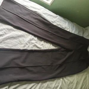 Svarta wide kostymbyxor  - Snygga svarta kostymbyxor från H&M i storlek S. Byxorna har en hög midja och ett breda ben. Passar dig som gillar minimalistisk stil.