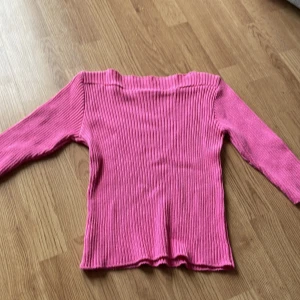 Rosa ribbad topp från New Look - Säljer en rosa trekvarts ärmad topp från New Look. Toppen är ribbad och har en rak hals. Jättefin rosa färg .