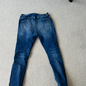 Dondup Alex superskinny jeans blå - Säljer ett par Dondup Alex jeans i superskinny fit. Klassisk blå tvätt med snygga slitningar och femficksmodell. Jeansen är tillverkade i Italien och har dragkedjegylf. Perfekta för dig som gillar en tajt passform och stilren look. Bara att höra av sig vid frågor 🙌😃
