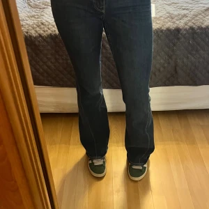 True Religion mörkblå bootcut jeans - Säljer ett par mörkblå jeans från True Religion med bootcut passform. Jeansen har snygga kontrastsömmar och ikoniska fickor bak med lock och silverfärgade knappar. Klassisk femficksmodell i jeansmaterial, perfekt för dig som gillar street och retrovibe. Köptes på jeansbolaget runt ett år sen i storlek w27. Använts väl men ser inga defekter förutom att de är för stora i midjan för mig där med har jag trätt igenom ett skosnöre men detta syns bara från insidan. Öppen för förhandling vid snabb affär