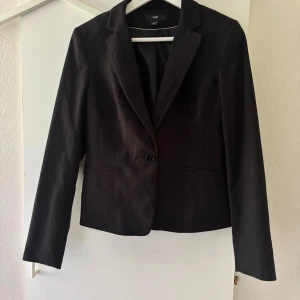 Kavaj  - Svart kavaj med innerficka. Katt och hund finns i hemmet