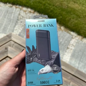 Remax RPP-96 Power Bank 10000mAh - Remax RPP-96 powerbank med 10000mAh kapacitet, 2 USB-portar (2.1A max), micro- och Type-C-ingång. Lätt och portabel, perfekt för att ladda mobiler och surfplattor på språng. Produkten är ny i obruten förpackning.