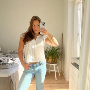 Neo noit vit blus  - Säljer en luftig vit blus med korta ärmar och fina spetsdetaljer vid halsringningen. Blusen har en lätt rynkad struktur och är tillverkad i ett tunt, skönt material som passar perfekt till jeans eller kjol. 💕💕Liten fläck på nederkanten