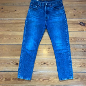 Blå Levis Jeans - Ett par blå jeans från märket Levis. Jeansen är i bra skick men finns tecken på använding. Jeansen har modellen 501, har storlek 28 i midja och storlek 30 i längd.