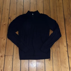 Helt ny utan prislapp! Mörkblå stickad half zip-tröja LMTD - Mörkblå stickad tröja från LMTD med kabelstickat mönster och half zip-dragkedja framtill. Tröjan har hög krage och långa ärmar, perfekt för lager på lager under kyliga dagar. Snygg och enkel att matcha med jeans eller annat.