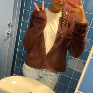 Vinröd kofta  - Mysig vinröd kofta från Gina Tricot med fluffig känsla. Koftan har rund halsringning, knappar framtill och långa ärmar. Perfekt att slänga över en t-shirt. Storlek L men sitter som S-xs. SLUTSÅLD