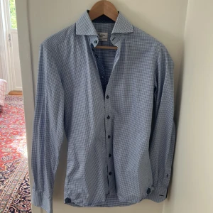 Blårutig skjorta från Stenströms - Snygg blårutig skjorta från Stenströms i slimline-passform. Tillverkad i tvåfaldig superbomull med klassisk krage, långa ärmar och knappar framtill. Insidan av knappslån har ett diskret prickigt mönster för extra stilpoäng.