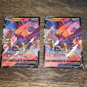 Talonflame V Pokémonkort - Två Talonflame V holografiska Pokémonkort i mycket fint skick. Båda har 190 HP och attacker som Fast Flight och Bright Wing. Inga synliga skador eller slitage på fram- eller baksida. Perfekt för samlare eller spelare som vill stärka sin kortlek.