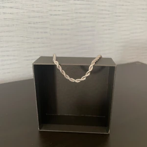 Flätat silverfärgat armband - Snyggt armband i silverfärg med flätad design. Kedjan har en tvinnad look som ger en cool och stilren känsla. Perfekt för dig som gillar minimalistiska accessoarer med det lilla extra. Lätt att matcha med andra smycken.