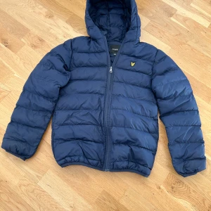 Mörkblå pufferjacka från Lyle & Scott - Säljer en mörkblå pufferjacka från Lyle & Scott Junior. Den är i super bra skick eftersom att den nästan är oanvänd. Nypris ca 1000.