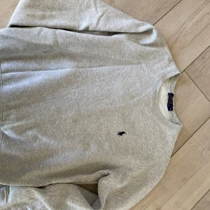 Grå sweatshirt från Polo Ralph Lauren - Klassisk grå sweatshirt från Polo Ralph Lauren med rund halsringning och broderad logga på bröstet. Väldigt bra skick