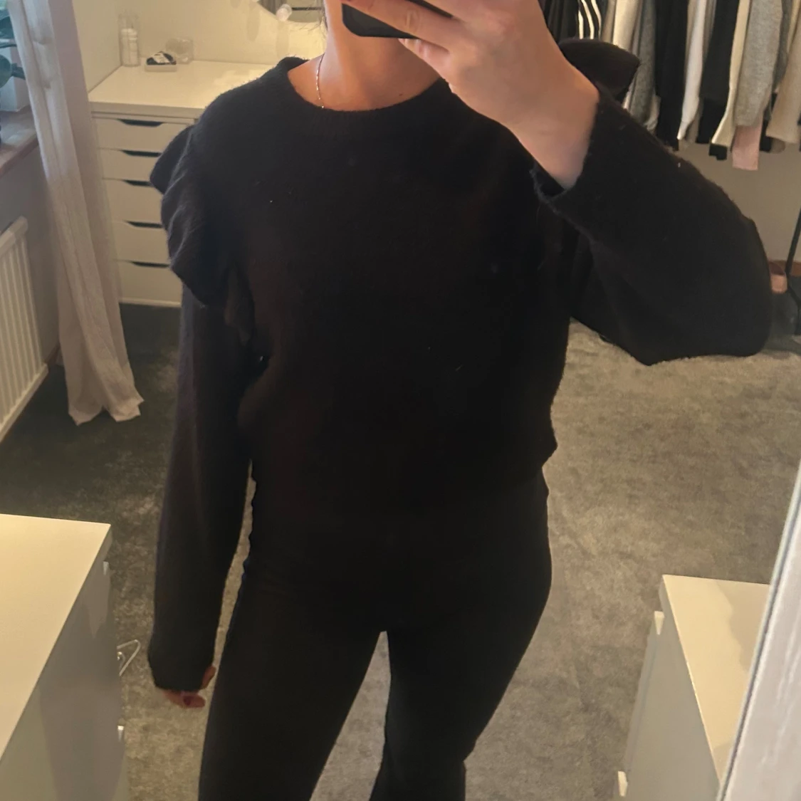 Svart stickad tröja med volangdetalj