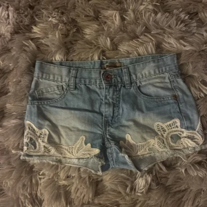 Ljusblå jeansshorts med spetsdetaljer 152 - Ett par blå jeans shorts med spetsdetaljer. Har inte andvänts så mycket så de är i bra skick. De är i storlek 152!💕