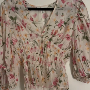 Blommig blus med v-ringning, S - Supersöt blommig blus med v-ringning. Blusen är ifrån H&M och har aldrig använts endast provad.
